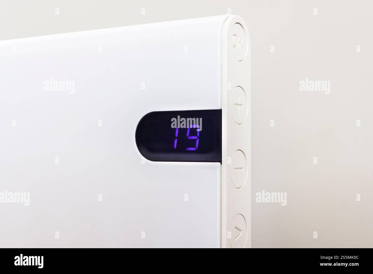 Nahaufnahme der Messung der Raumtemperatur. Moderner elektrischer Heizkörper an der Wand, Innenraum, Großbritannien Stockfoto