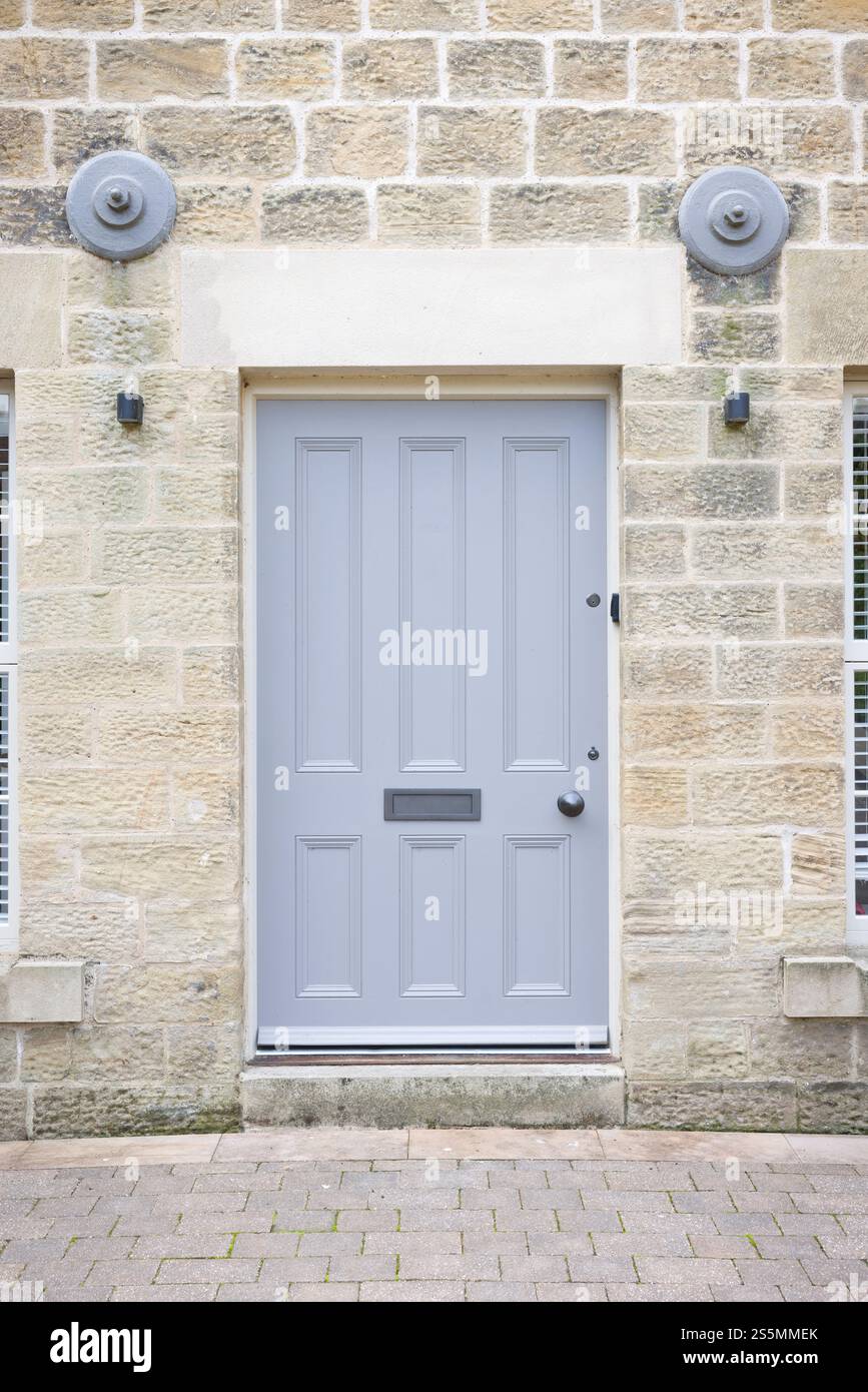 Graue Holztür zu einem Apartment in einem umgebauten alten Mühlenhaus. Nidderdale, Yorkshire Dales, Großbritannien Stockfoto