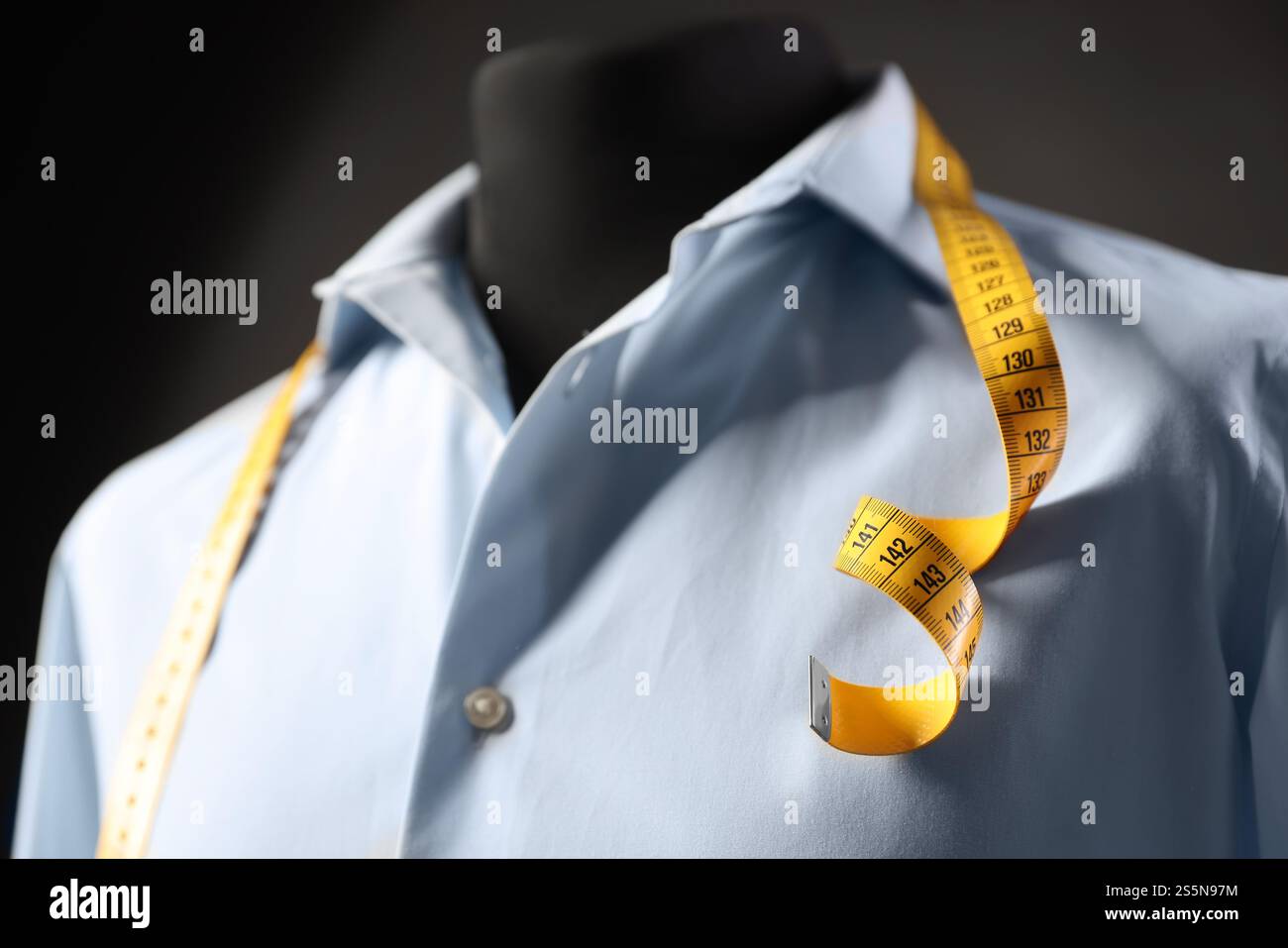 Männliche Schaufensterpuppe mit Hemd und Maßband auf dunklem Hintergrund, Nahaufnahme Stockfoto