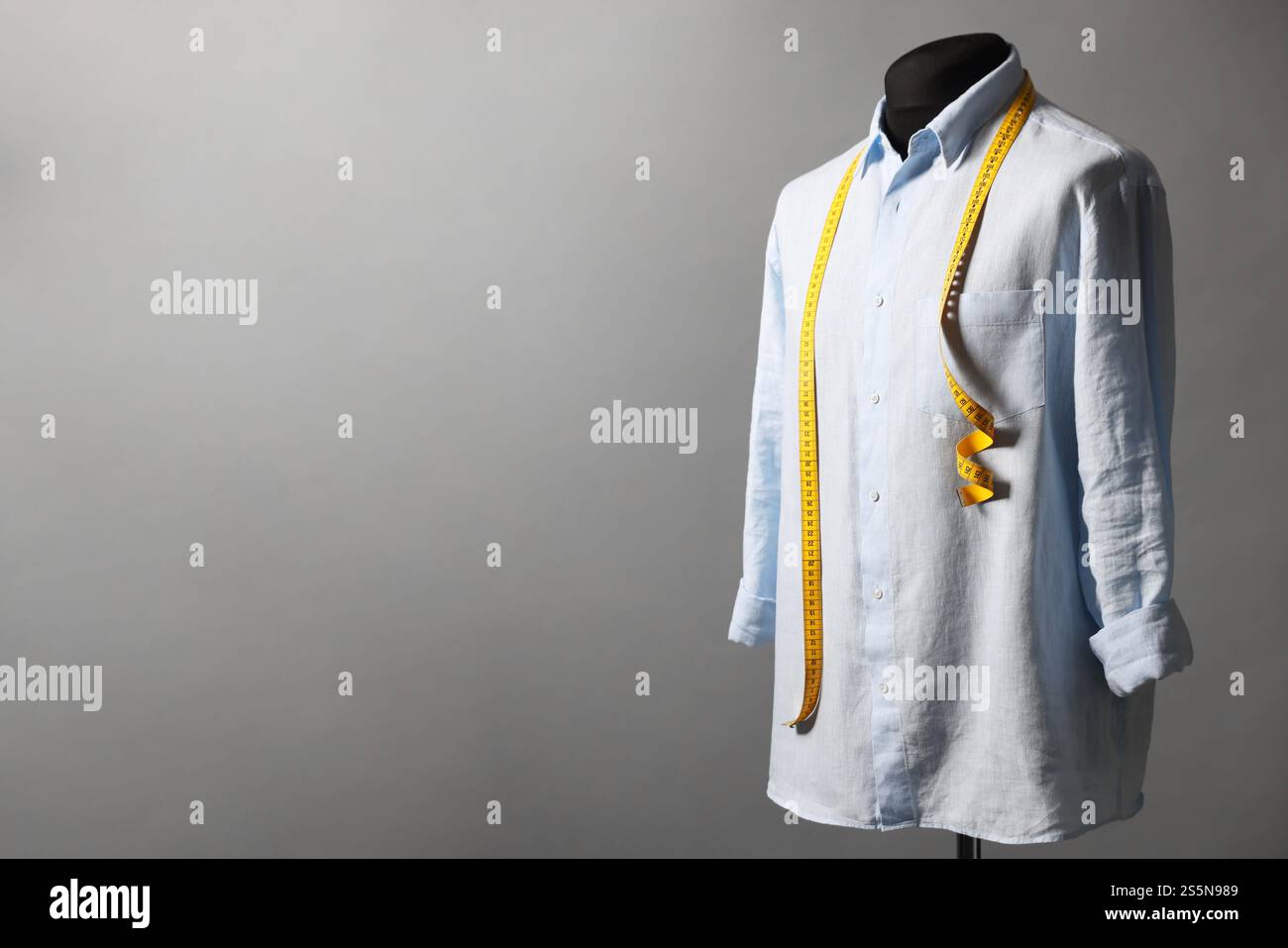 Männerpuppe mit Hemd und Maßband auf grauem Hintergrund, Platz für Text Stockfoto