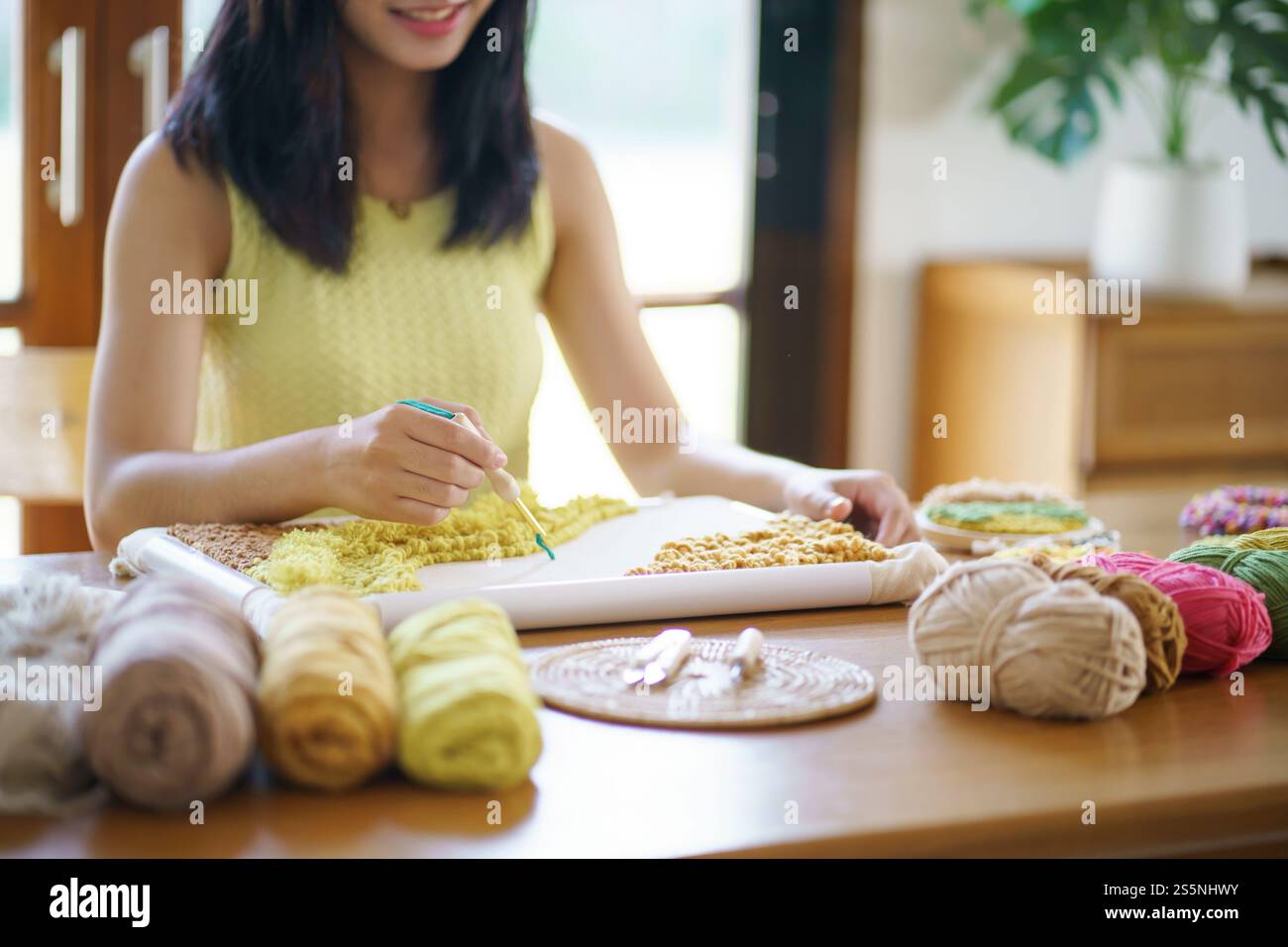 Stanznadel. Asiatische Frau, die handgemachtes Hobby-Stricken in der Atelierwerkstatt herstellt. Designer-Arbeitsplatz Handgefertigtes Bastelprojekt DIY Stickkonzept Stockfoto