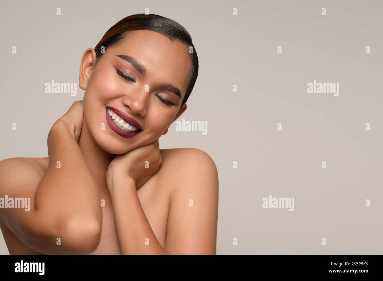 Kopffoto, Porträt einer fröhlichen Frau, die Hand auf den Nacken gelegt hat, umarmt sich Gefühle mit einem zahnigen Lächeln, das isoliert auf grauem Hintergrund posiert Stockfoto Kopffoto, Porträt einer fröhlichen Frau, die Hand auf den Nacken gelegt hat, umarmt sich Gefühle mit einem zahnigen Lächeln, das isoliert auf grauem Hintergrund posiert Stockfoto