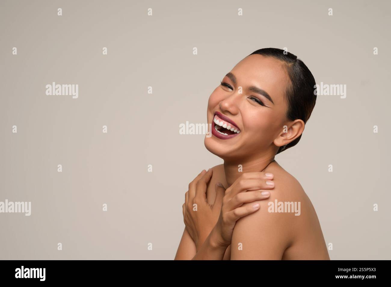 Kopffoto, Porträt einer fröhlichen Frau, die sich mit einem zahnigen Lächeln umarmt, isoliert auf grauem Hintergrund im Studio, Kopierraum Stockfoto Kopffoto, Porträt einer fröhlichen Frau, die sich mit einem zahnigen Lächeln umarmt, isoliert auf grauem Hintergrund im Studio, Kopierraum Stockfoto
