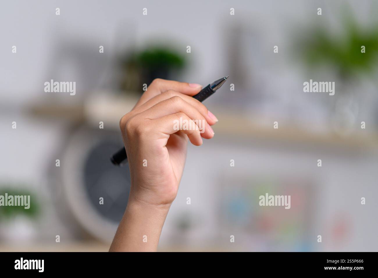 Weibliche Hand, die einen Stift hält. Selektiver Fokus Stockfoto
