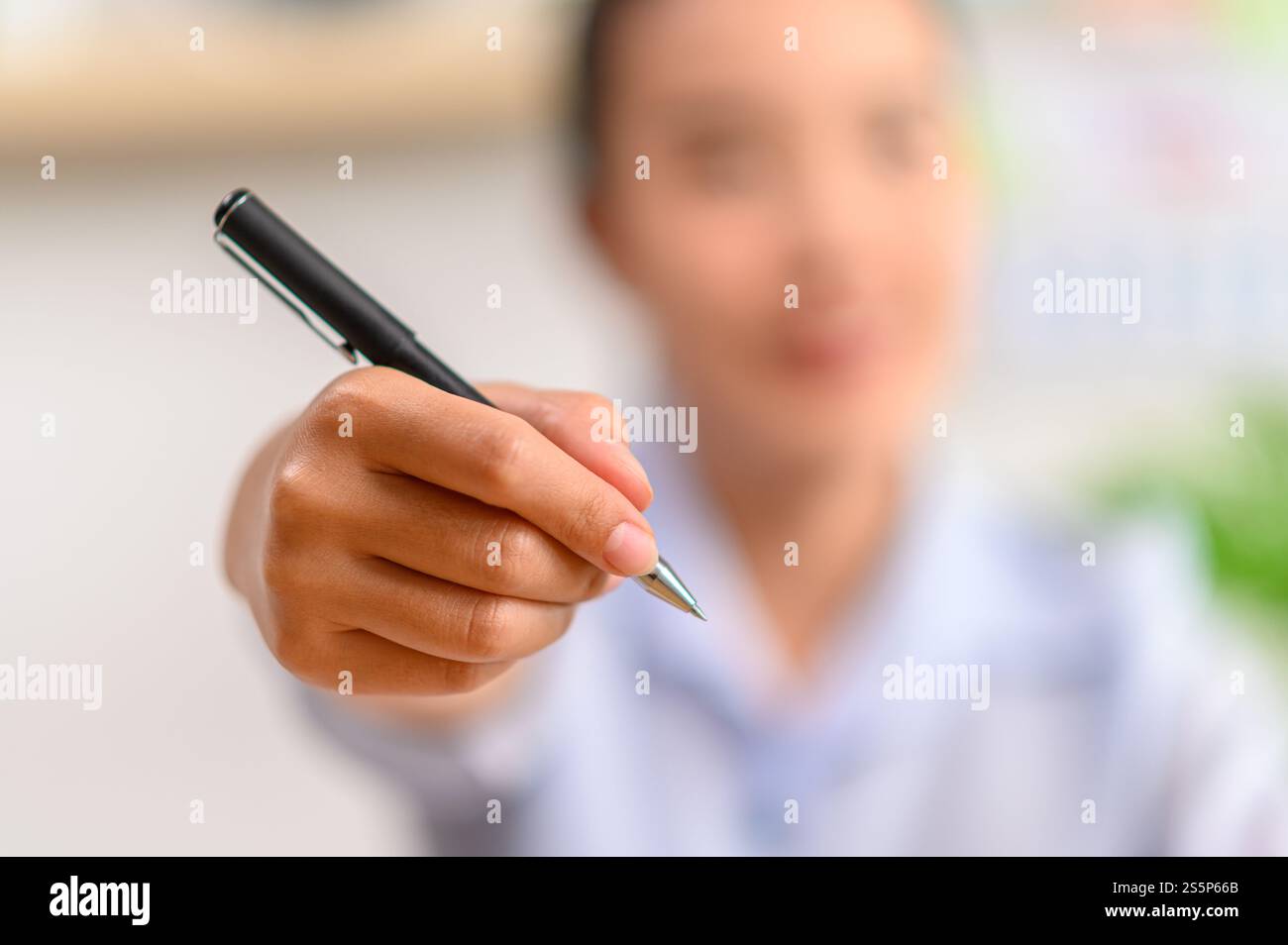 Weibliche Hand, die einen Stift hält. Selektiver Fokus Stockfoto
