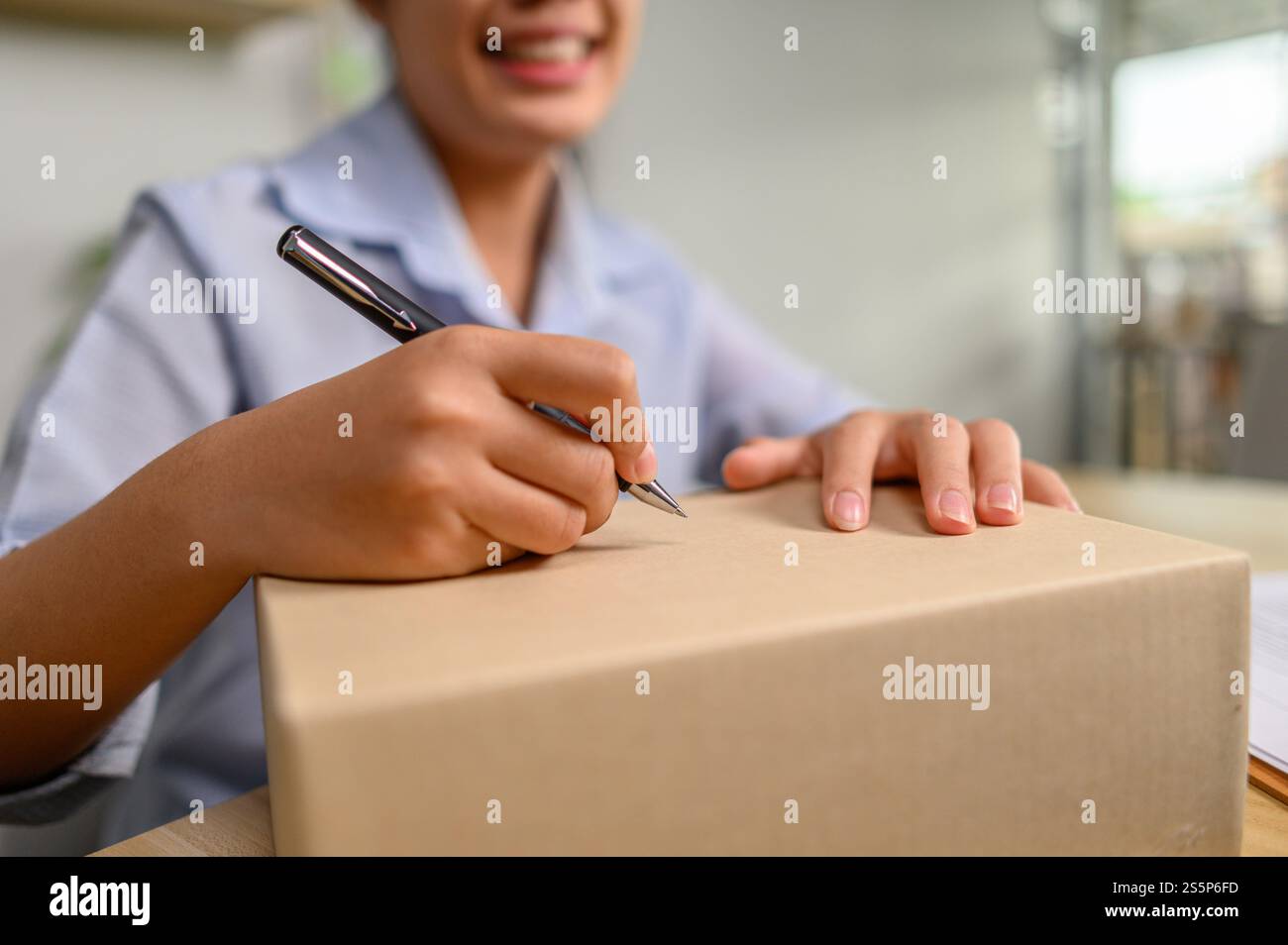 Frau, die Pakete zur Zustellung anspricht. Selektiver Fokus Stockfoto