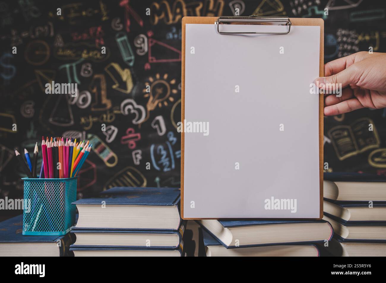 Hand hält das Clipboard im Klassenzimmer Stockfoto