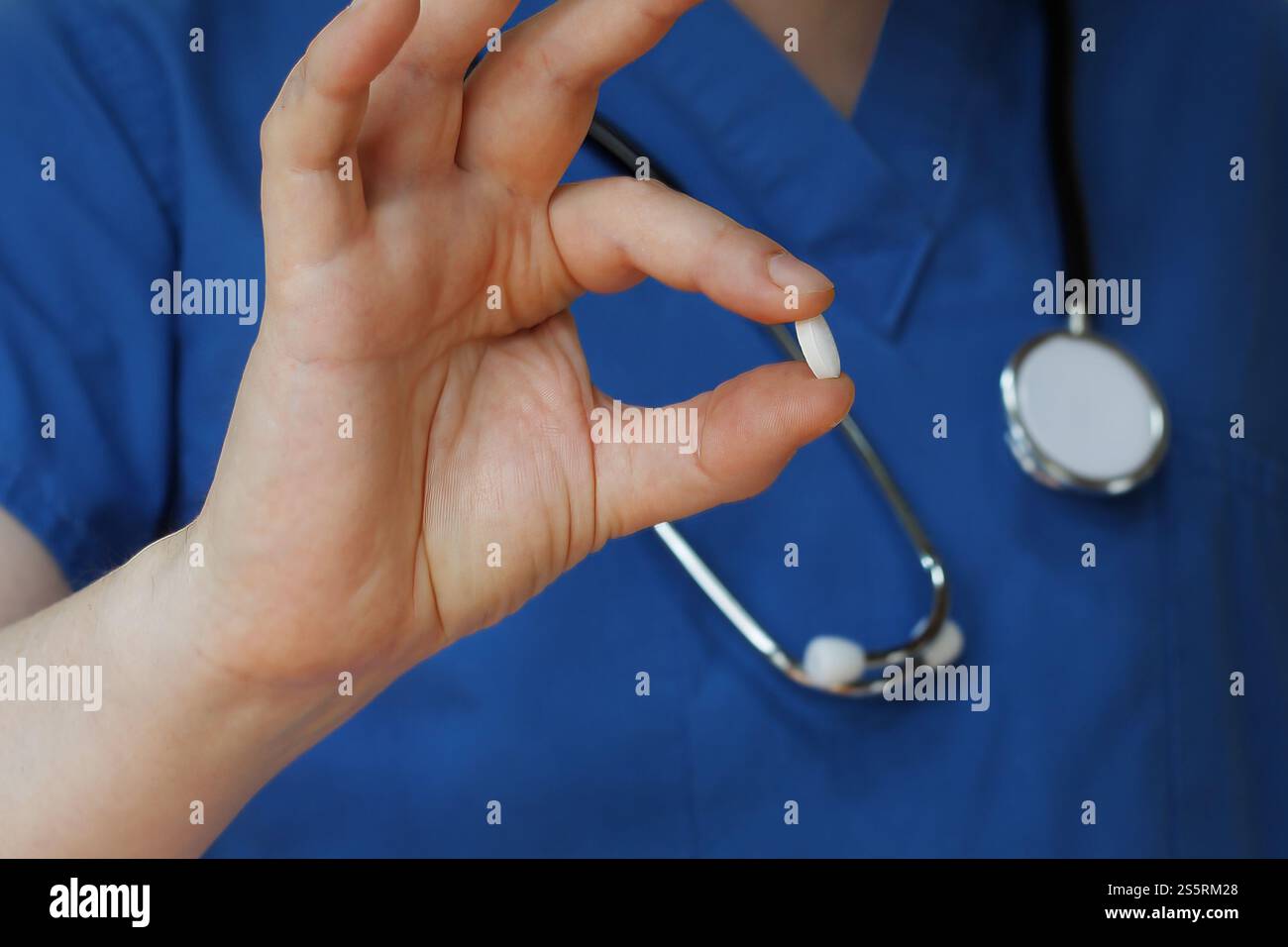Nahaufnahme Arzt in blauen Peelings mit weißer Pille, Medikamente Stockfoto