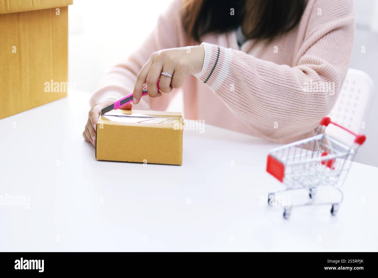 Frau auspackt aus, nachdem sie Online-Shopping zu Hause gekauft hat Stockfoto
