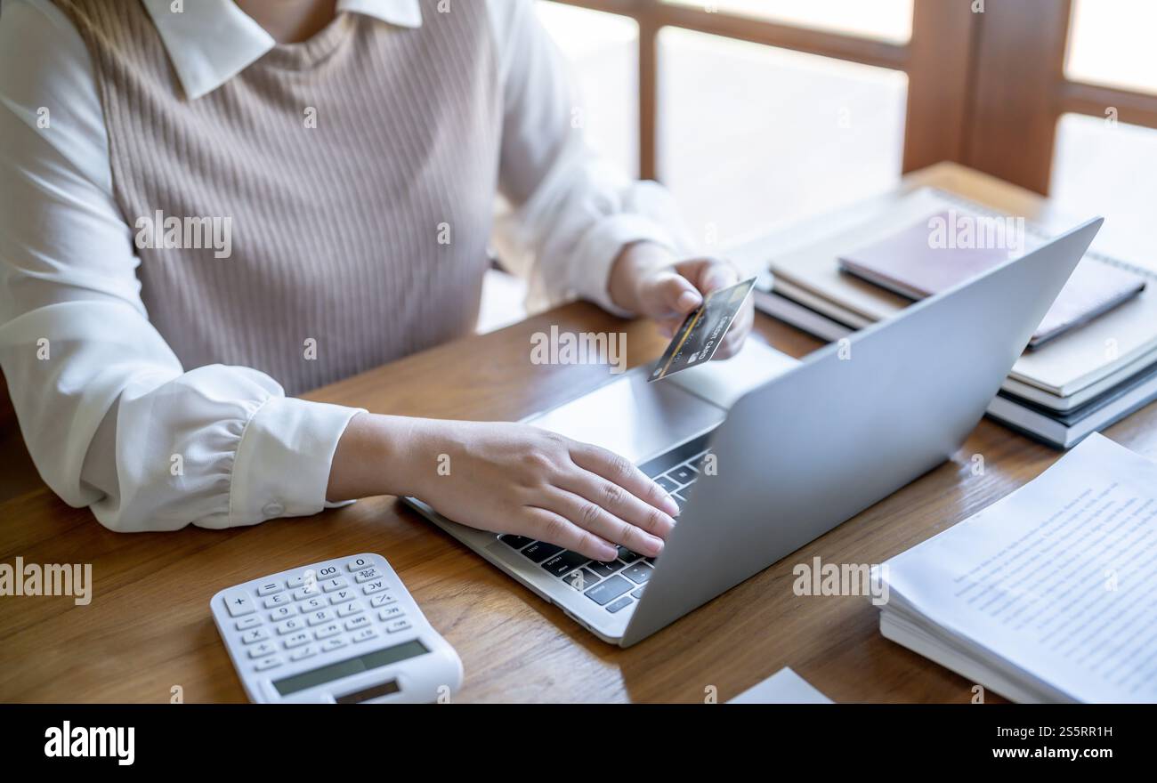 Frau, die auf einem Laptop mit Kreditkarte für Internet Online-E-Commerce-Einkaufen Geld ausgeben Online-Einkaufen Handy-Laptop-Technologie Stockfoto