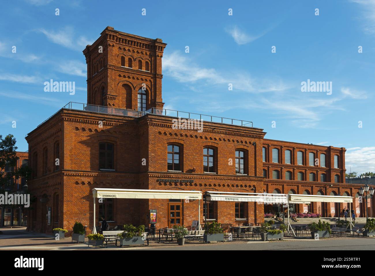 Backsteingebäude mit Café unter blauem Himmel und urbanem Flair an einem sonnigen Tag, Manufaktura, Lodz, Lodz, Lodz, Polen, Europa Stockfoto