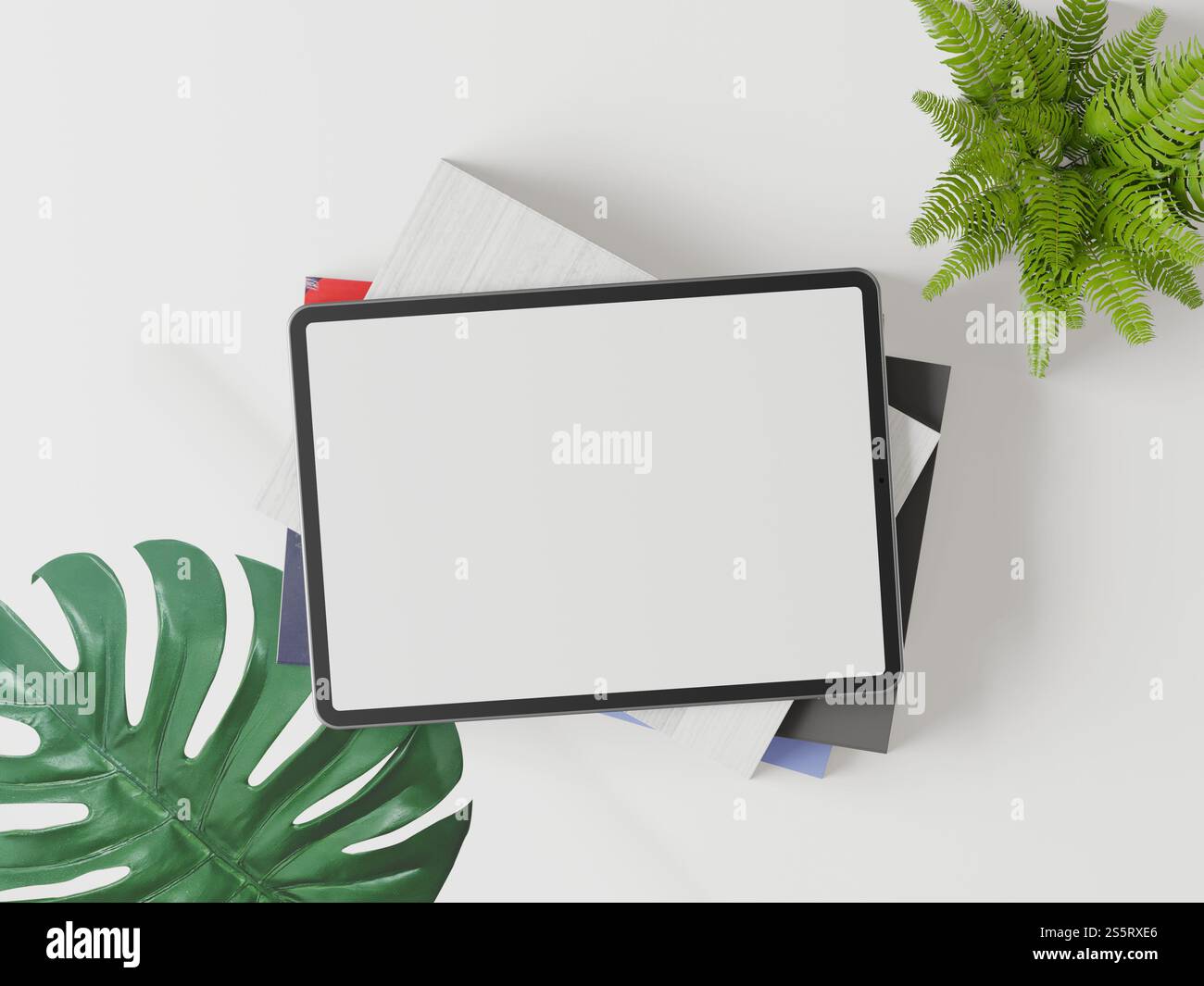 Die Tablette wird auf einem weißen Hintergrund platziert und hat grüne Blätter. Stockfoto