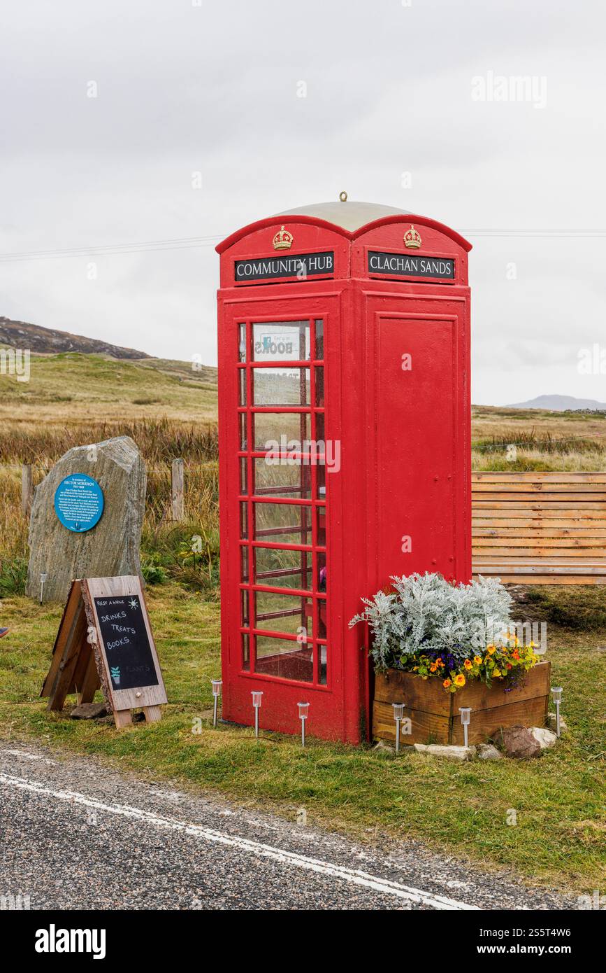 September 2024. Schottland, Hebriden. Isle of North Uist. „Clachan Sands Community Hub“. Eine traditionelle rote Telefonzelle, die als winzige libr Stockfoto