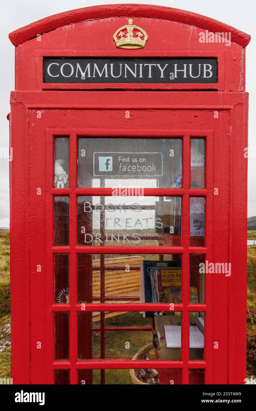 September 2024. Schottland, Hebriden. Isle of North Uist. „Clachan Sands Community Hub“. Eine traditionelle rote Telefonzelle, die als winzige libr Stockfoto
