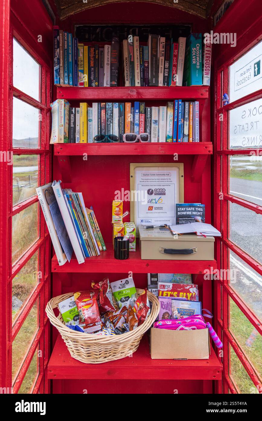 September 2024. Schottland, Hebriden. Isle of North Uist. „Clachan Sands Community Hub“. Eine traditionelle rote Telefonzelle, die als winzige libr Stockfoto