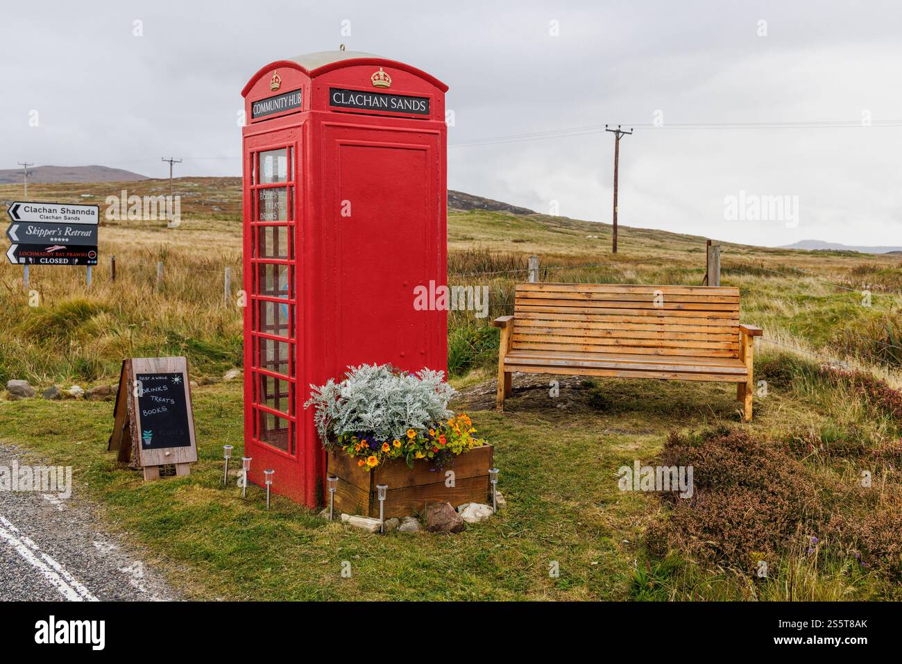 September 2024. Schottland, Hebriden. Isle of North Uist. „Clachan Sands Community Hub“. Eine traditionelle rote Telefonzelle, die als winzige libr Stockfoto