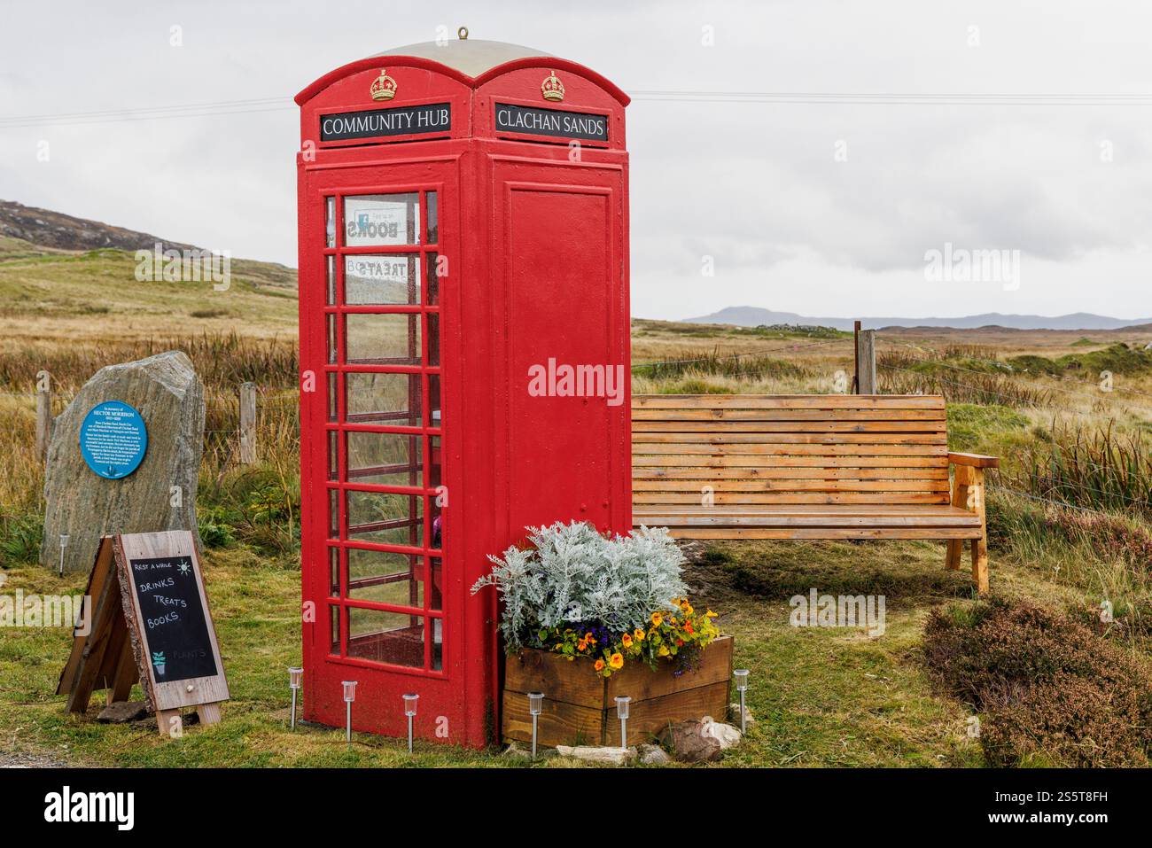 September 2024. Schottland, Hebriden. Isle of North Uist. „Clachan Sands Community Hub“. Eine traditionelle rote Telefonzelle, die als winzige libr Stockfoto