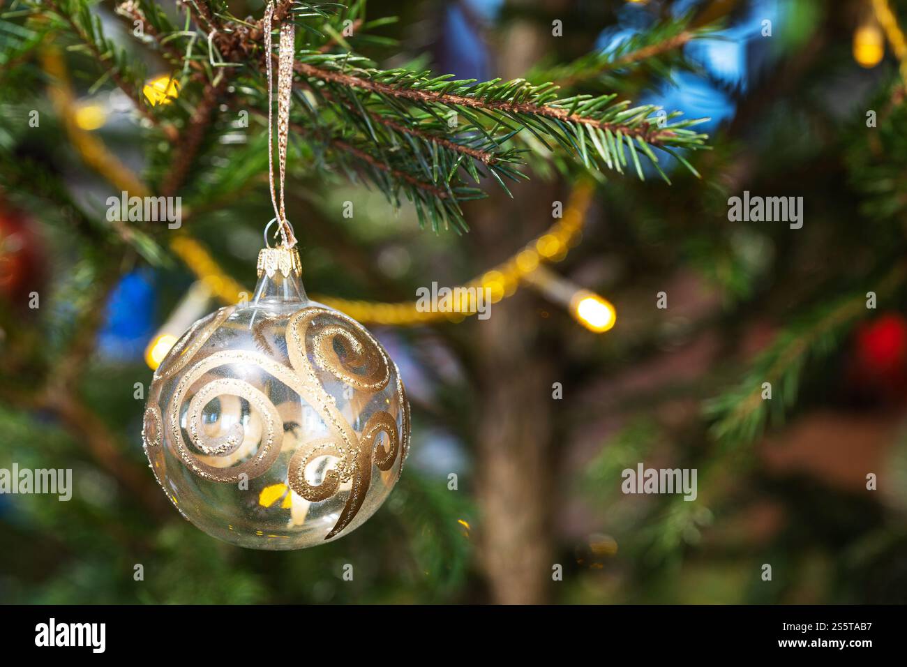Glaskugel mit goldenem Dekor und natürlichem weihnachtsbaum aus nächster Nähe Stockfoto