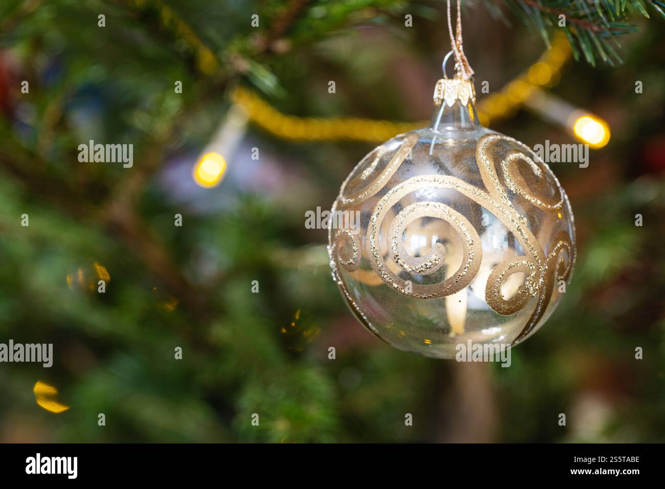 Glaskugel mit goldenem Muster auf natürlichem weihnachtsbaum aus nächster Nähe Stockfoto