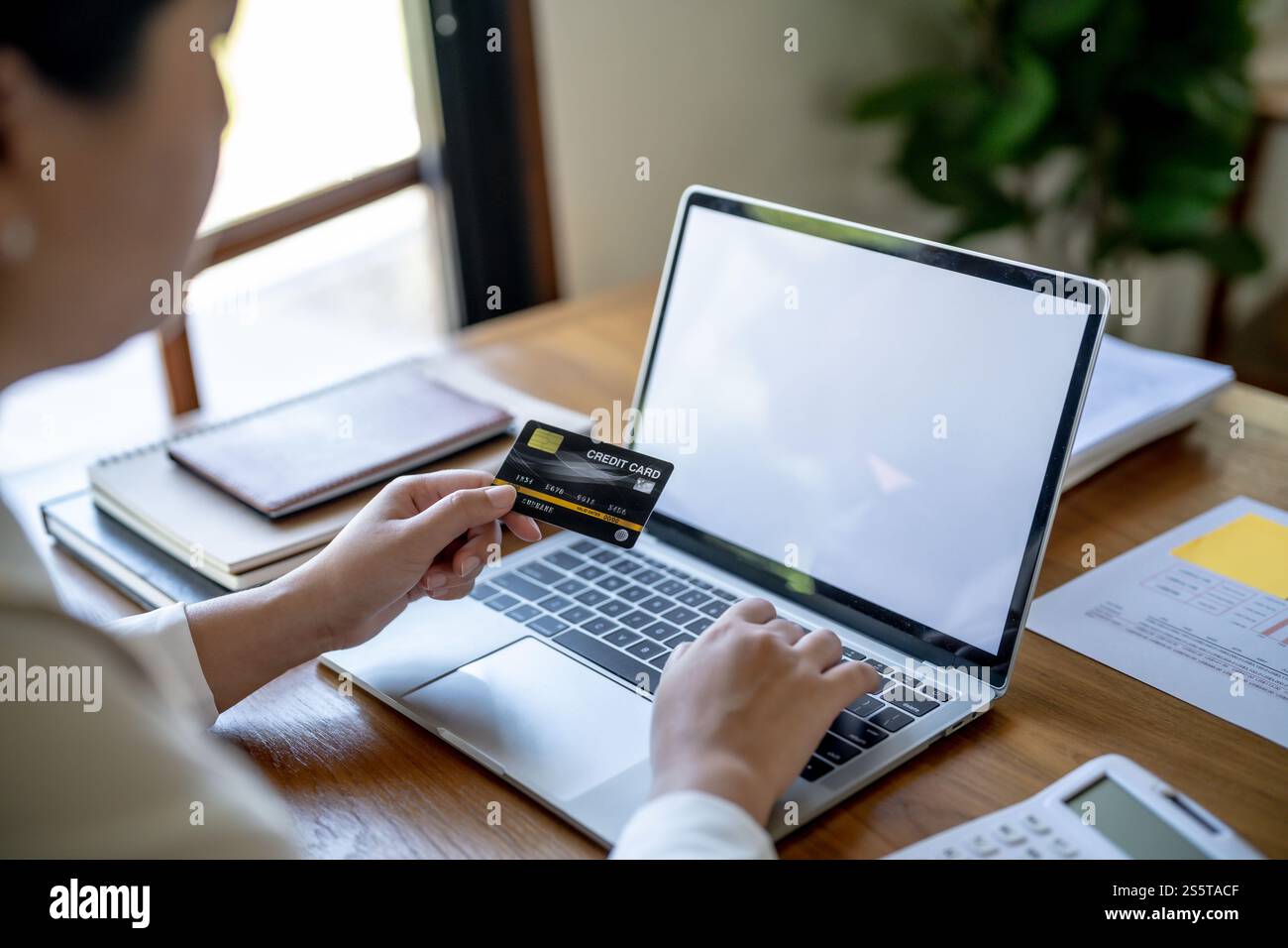 Frau, die auf einem Laptop mit Kreditkarte für Internet Online-E-Commerce-Einkaufen Geld ausgeben Online-Einkaufen Handy-Laptop-Technologie Stockfoto