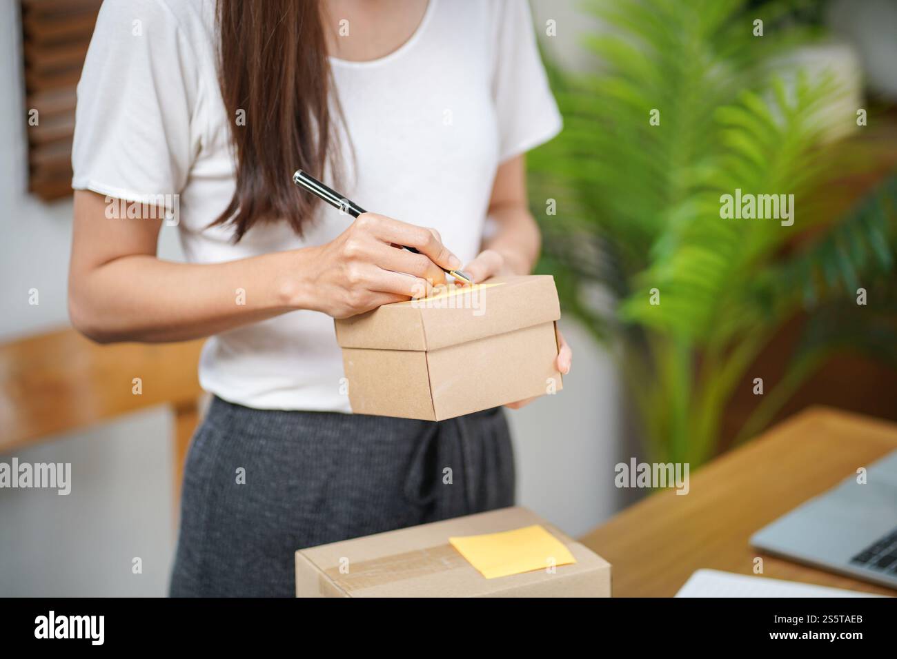 Asiatische Frau, die Paketzustellbox vorbereitet Versand für den Einkauf Online-Zustellung Postservice Menschen und Versandkonzept. Stockfoto