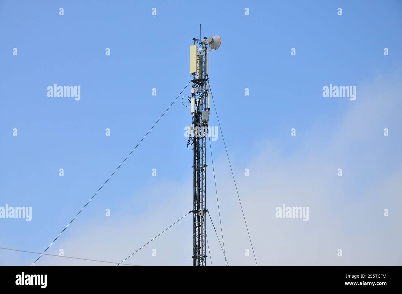 Telekommunikationsturm zur Übertragung von Funkwellen. Funkturm aus Metall mit Drähten und Kommunikatoren gegen den blauen klaren Himmel. Kabellos Stockfoto
