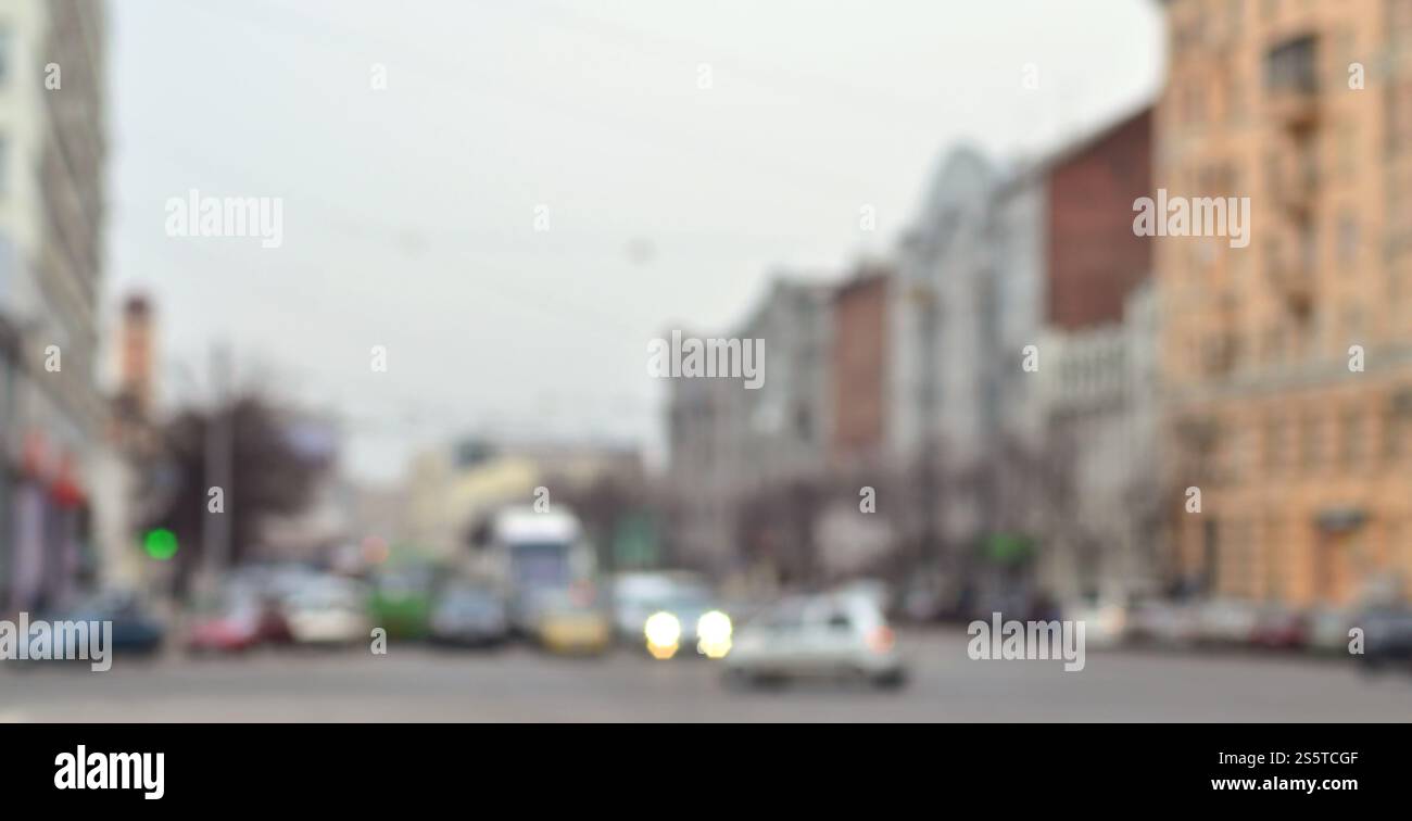 Verschwommene und unscharfe Landschaft mit einer Stadtstraße während des Verkehrs. In der Abendzeit fahren viele Autos entlang der Straße mitten in der Stadt. Stockfoto