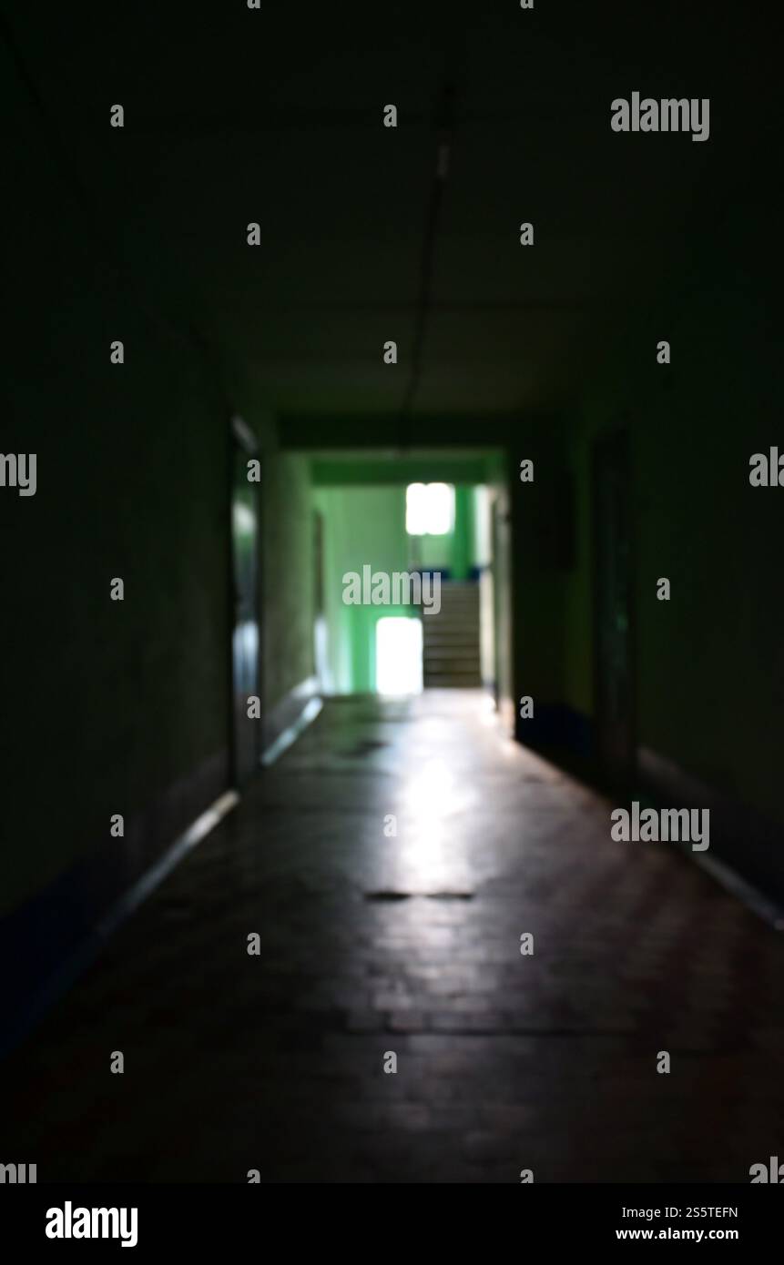 Die verschwommenes Bild von düsteren Korridor von einem vernachlässigten öffentlichen Gebäude. Defokussierten Bild von einem öffentlichen Raum in einem schlechten Wohn- hochhaus Stockfoto