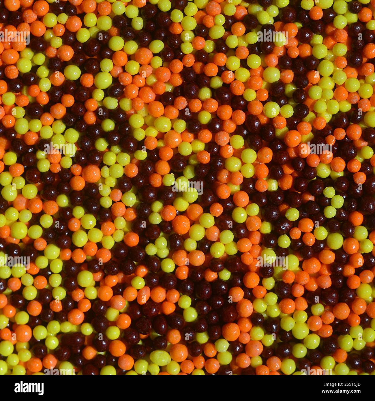 Hintergrundbild einer Vielzahl von farbigen glasierten Pulvern in Form von kleinen Kugeln. Eine große Anzahl von süßen, bunten Perlen von sehr kleiner Größe für Stockfoto