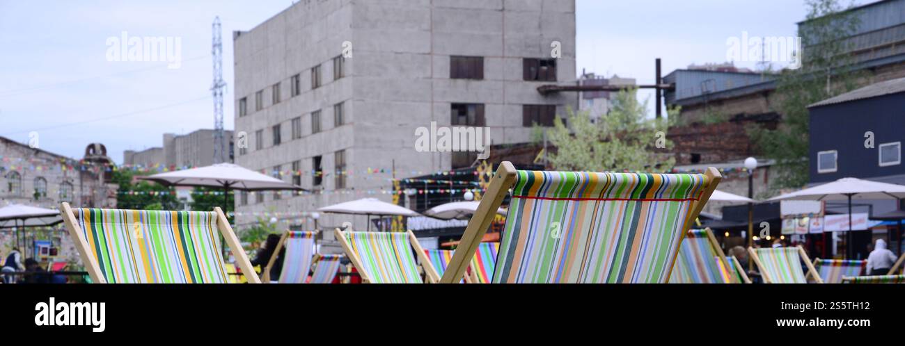 Liegestühle auf einem Rasen. Ruhen Sie sich auf dem Festival aus, im Urlaub. Gartenliegen auf grünem Gras. Gartenbett zum Sonnenbaden und Ausruhen. Sommerstuhl. Chaise Stockfoto