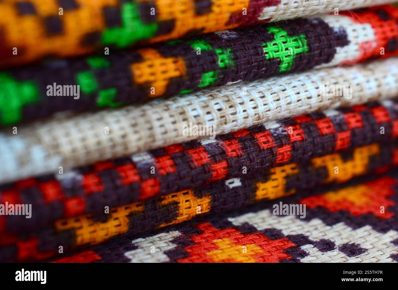 Stapel traditioneller ukrainischer Stickmuster auf Textilgewebe. Gestricktes Canvas mit farbigem Pixeldesign. Stapel traditioneller Produkte Stockfoto