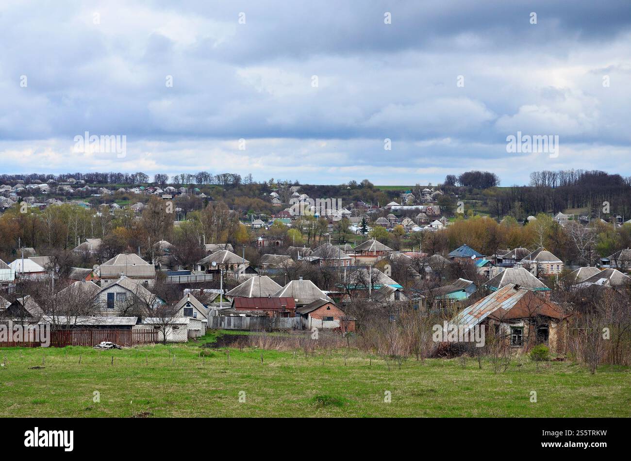 Eine ländliche Landschaft mit vielen Privathäusern und grüne Bäume. Suburban Panorama an einem bewölkten Nachmittag. Ein Ort, weit von der Stadt entfernt Stockfoto