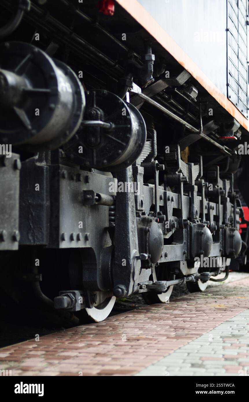 Räder einer modernen russischen Lokomotive, Blick von der Seite. Konzept der Transportbranche. Schwere Räder und Mechanismus unter dem Elektrozug. Räder von Stockfoto