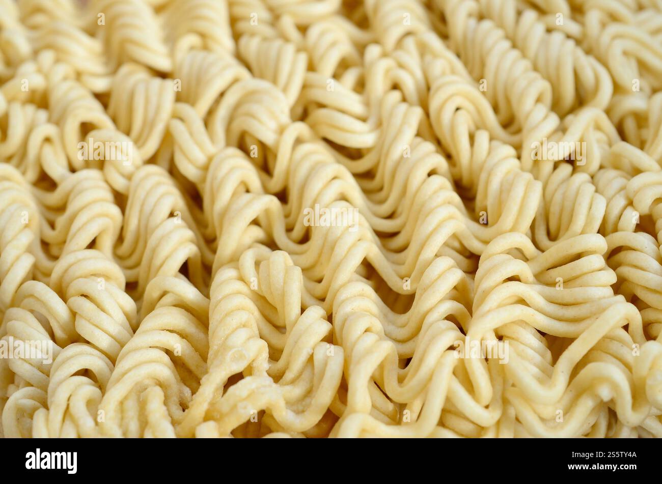 Nahaufnahme von gelben, trockenen Instantnudeln. Traditionelles chinesisches Essen Stockfoto