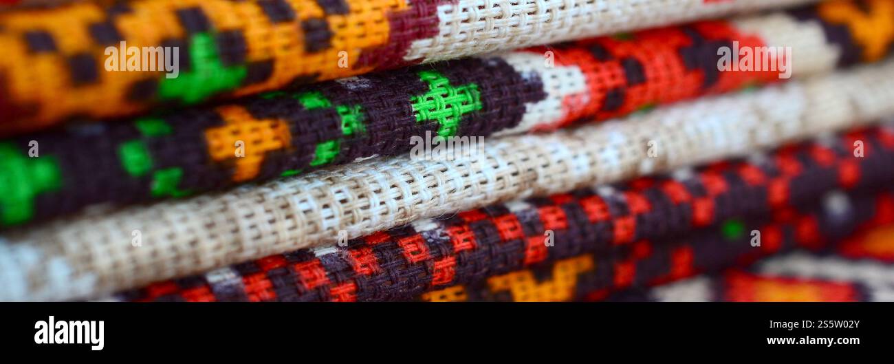 Stapel traditioneller ukrainischer Stickmuster auf Textilgewebe. Gestricktes Canvas mit farbigem Pixeldesign. Stapel traditioneller Produkte Stockfoto