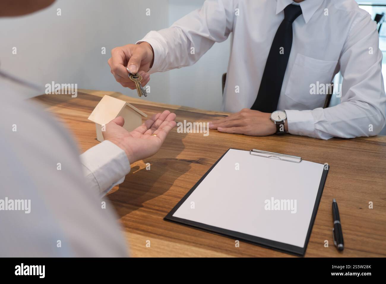 Geschäftsleute, die einen Vertrag mit Immobilienmaklerkonzept für Berater und HausversicherungImmobilien unterzeichnen Stockfoto