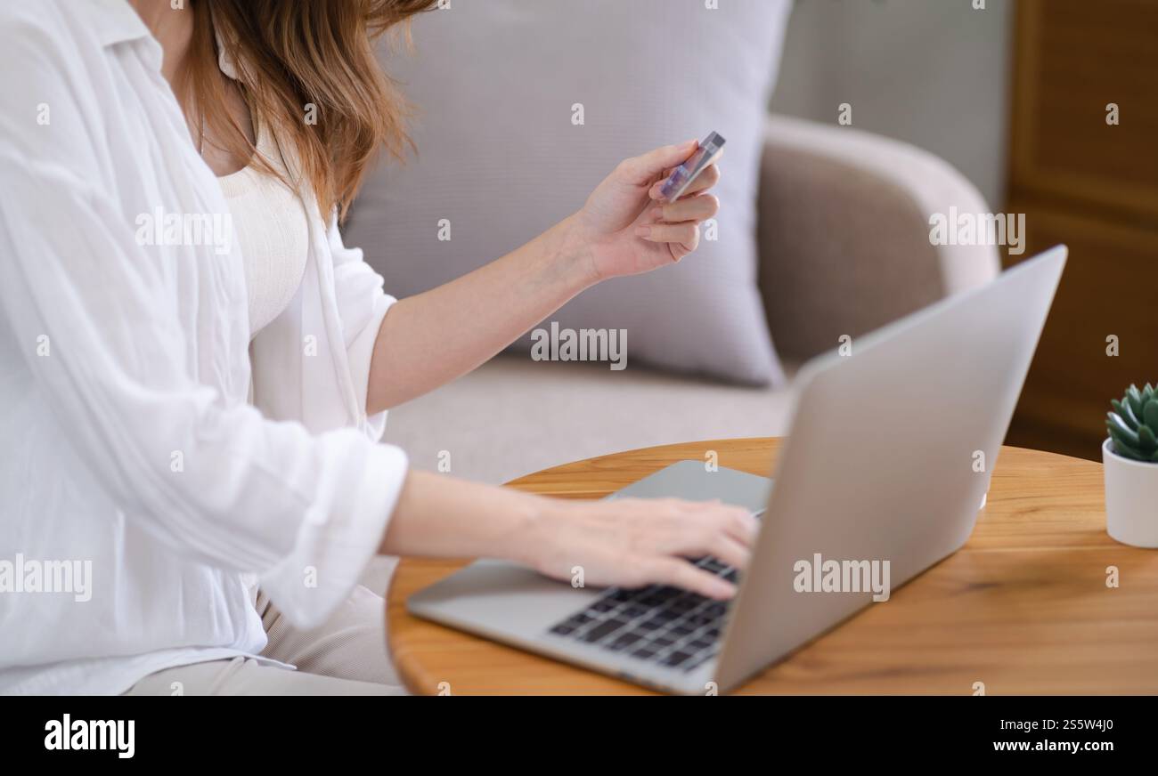 Frau, die auf einem Laptop mit Kreditkarte für Internet Online-E-Commerce-Einkaufen Geld ausgeben Online-Einkaufen Handy-Laptop-Technologie Stockfoto