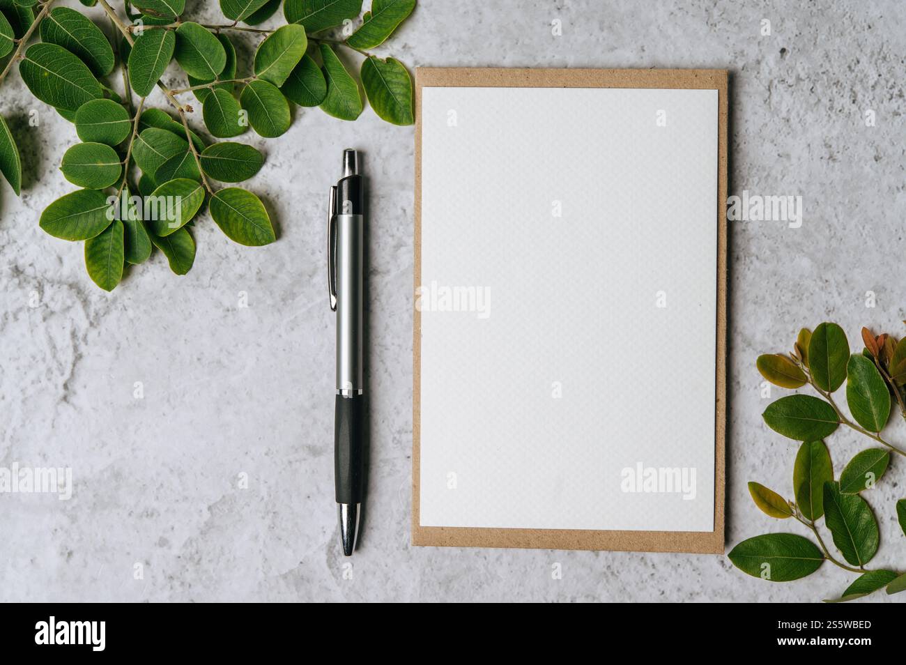 Eine leere Karte mit Umschlag, Stift und Blatt wird auf weißem Hintergrund platziert Stockfoto