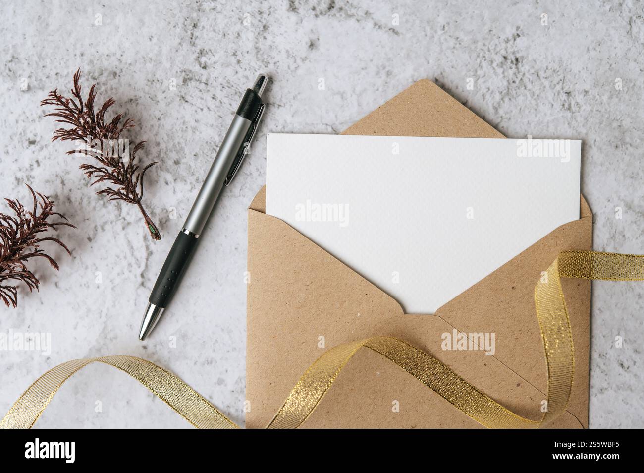 Eine leere Karte mit Umschlag, Stift und Blatt wird auf weißem Hintergrund platziert Stockfoto
