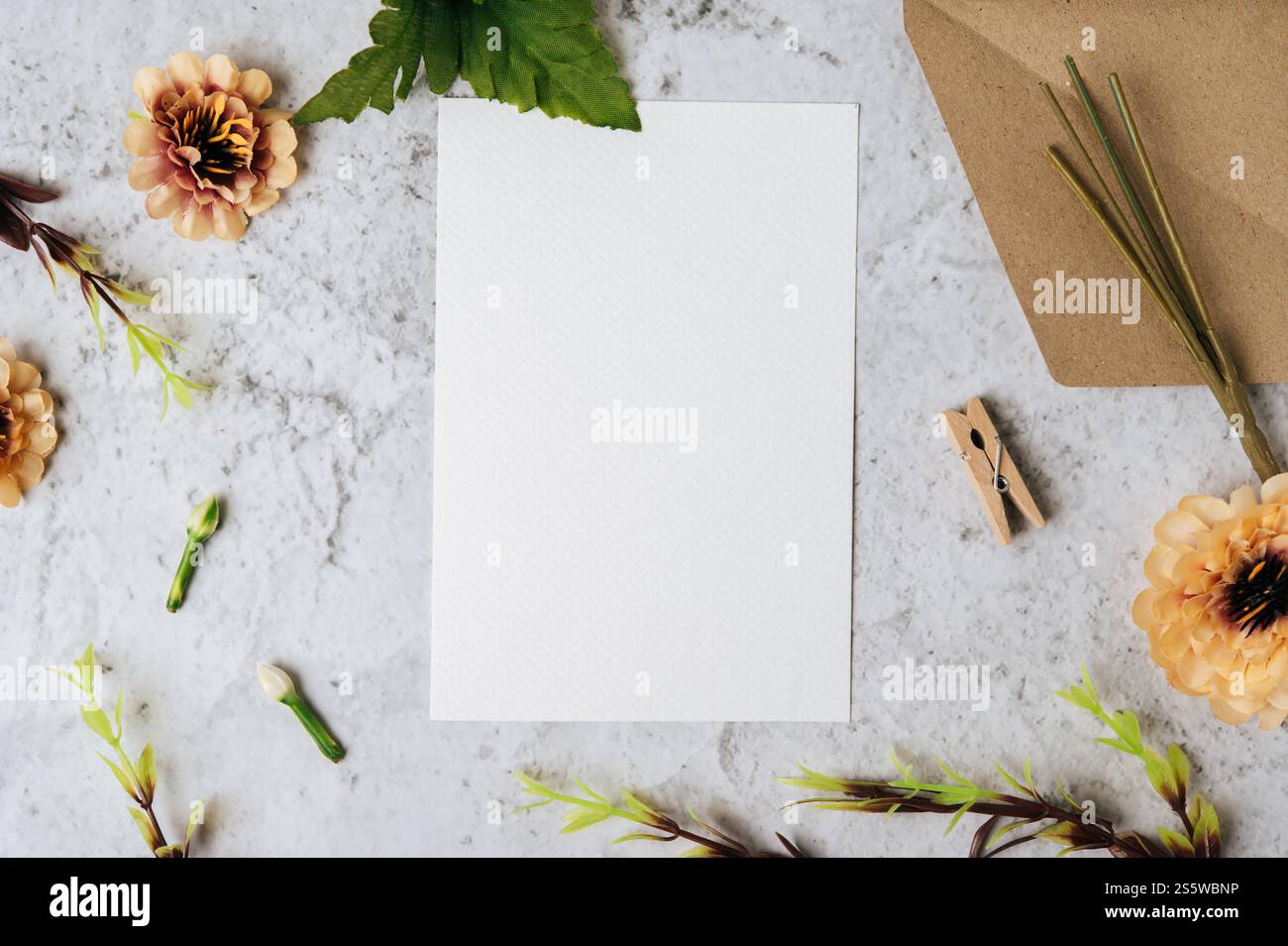 Eine leere Karte mit Umschlag und Blume ist auf weißem Hintergrund platziert Stockfoto