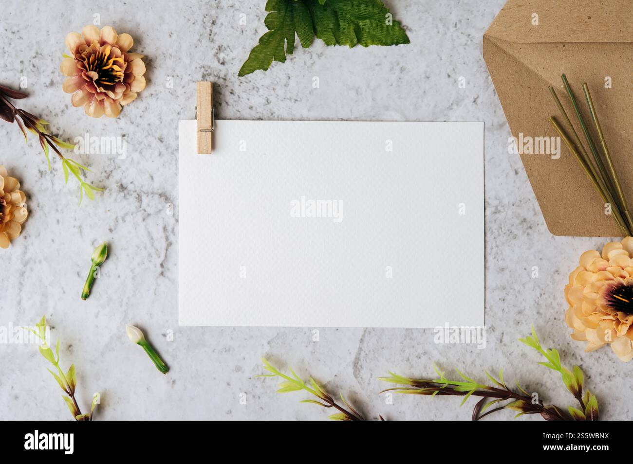 Eine leere Karte mit Umschlag und Blume ist auf weißem Hintergrund platziert Stockfoto