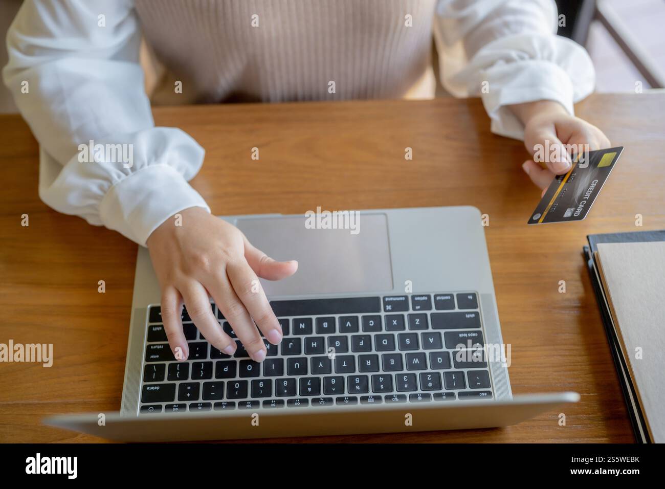 Frau, die auf einem Laptop mit Kreditkarte für Internet Online-E-Commerce-Einkaufen Geld ausgeben Online-Einkaufen Handy-Laptop-Technologie Stockfoto