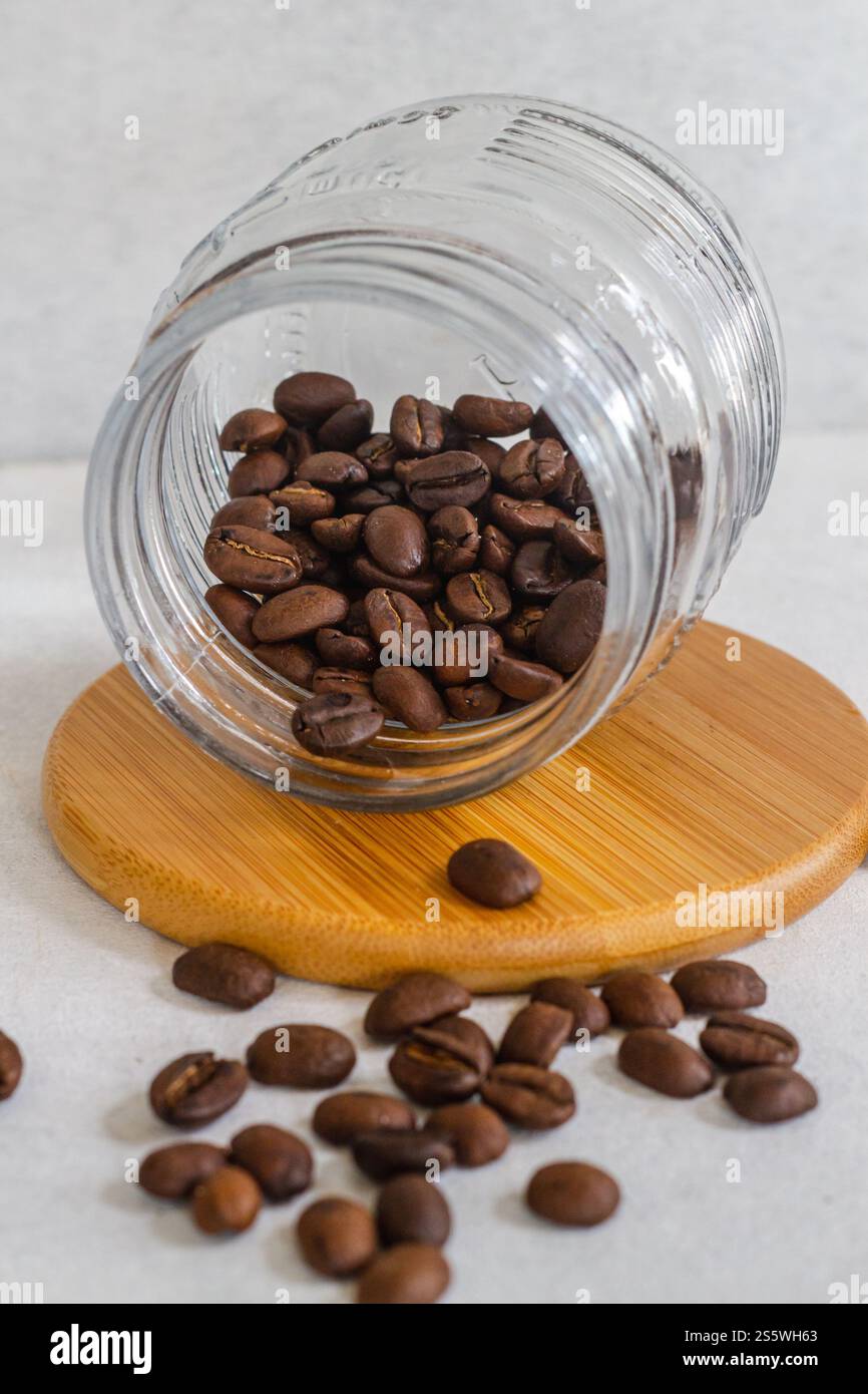 Top Nehmen Sie Kaffeebohnen in einer Glasschale auf einem Holzsockel auf weißem Hintergrund isoliert Stockfoto