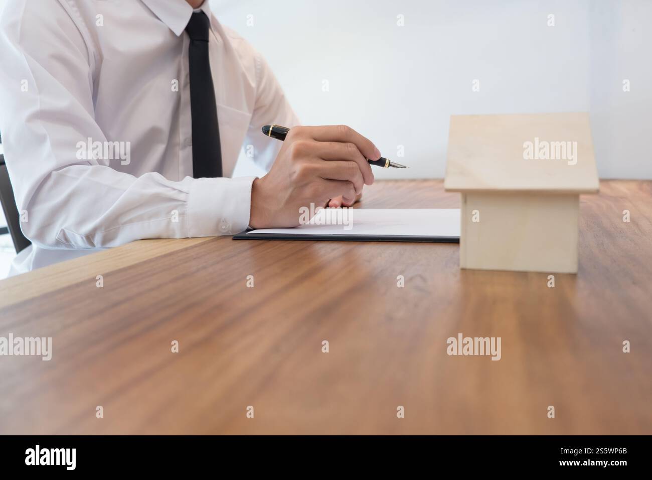 Geschäftsleute, die einen Vertrag mit Immobilienmaklerkonzept für Berater und HausversicherungImmobilien unterzeichnen Stockfoto