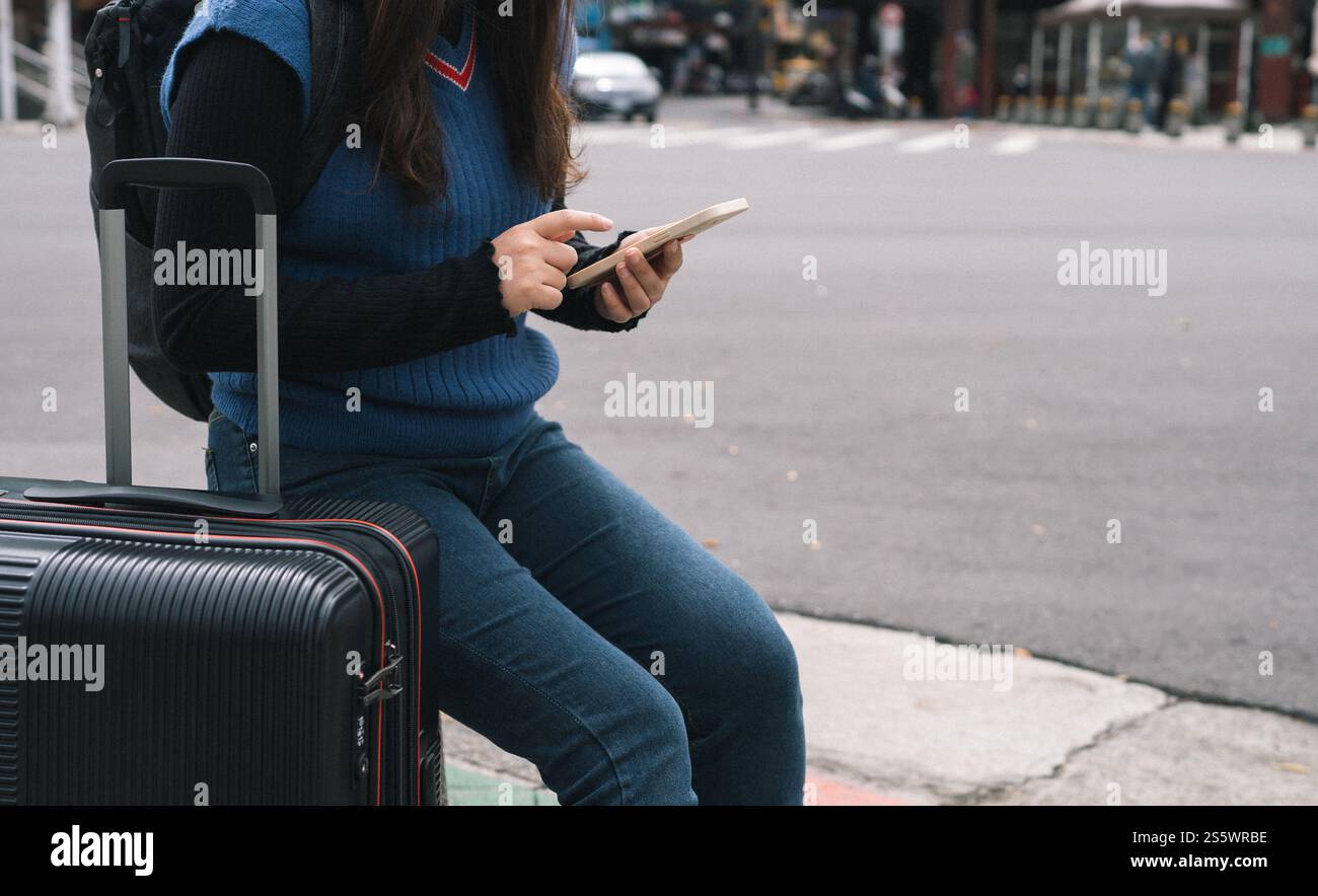 Frau mit Gepäck in der Innenstadt auf der Suche nach dem Standort in der Kartenanwendung online auf dem Smartphone mit GPS-Navigation Stockfoto
