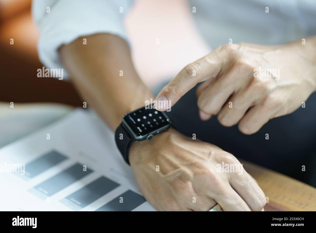 Geschäftsmann mit Blick auf Smart Watch in der Office Online Connect Gadget-Technologie. Stockfoto
