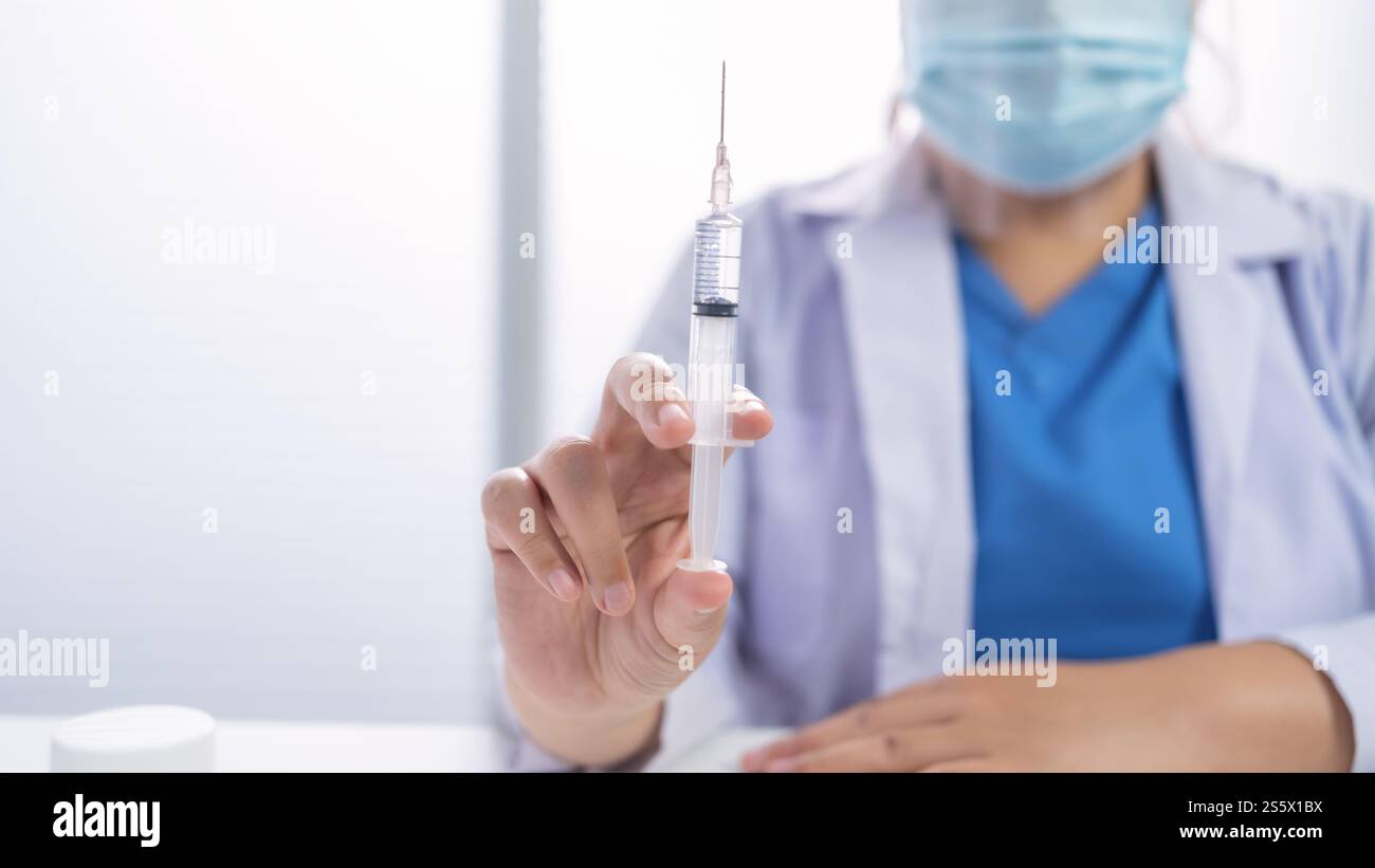 Professionelle medizinische asiatische Frau Arzt mit Spritze medizinische Injektion in der Hand Impfstoff injizieren Gesundheit Arzneimittel Impfung Influenza Kampf gegen Stockfoto