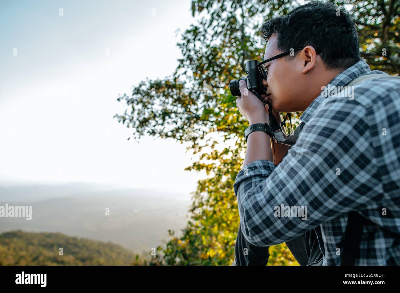 Junger asiatischer Wanderer und Rucksack machen Fotos im Wald mit der Kamera. Kopierbereich Stockfoto