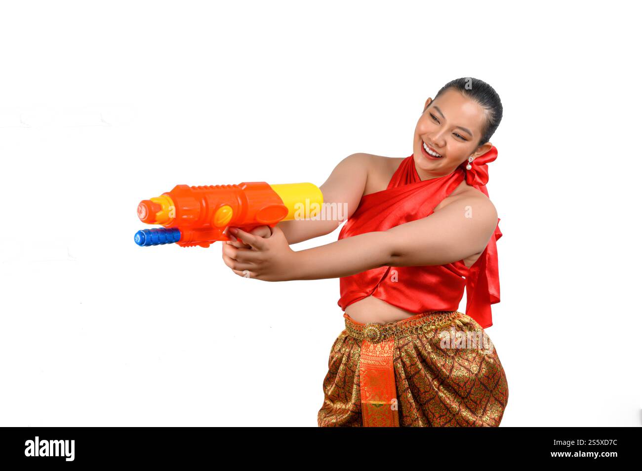 Porträt schöne Frau im Songkran Festival mit traditioneller thailändischer Tracht stehend und mit Wasserpistole mit Lächeln und Kamera auf weiß Stockfoto