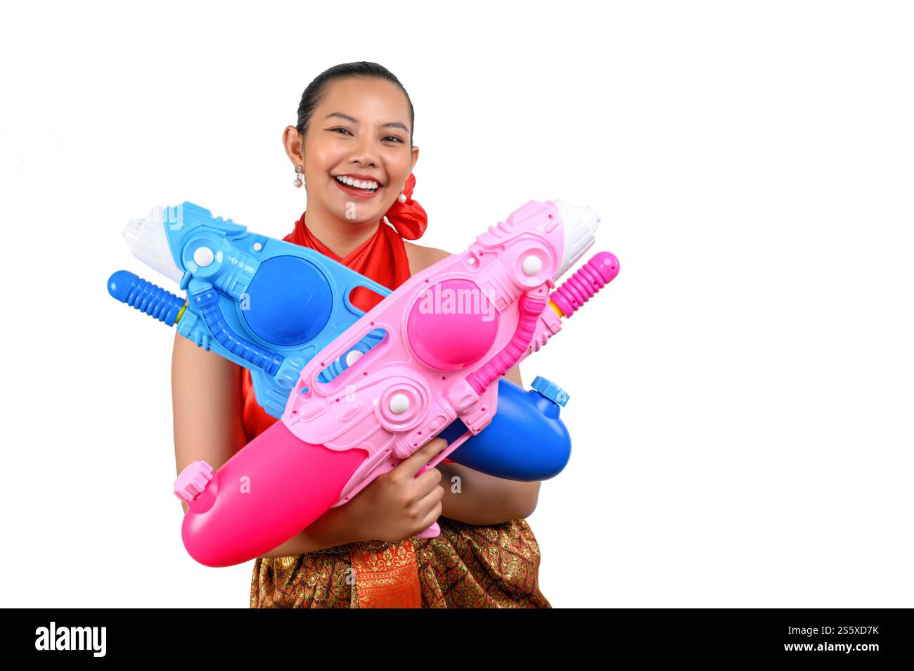 Portrait schöne Frau im Songkran Festival mit traditioneller thailändischer Tracht stehend und mit zwei Wasserpistolen mit einem Lächeln und einer Kamera auf Stockfoto